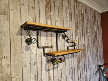 Industrial steampunk wall shelf with wood planks and metal pipe fittings on rustic panel wall