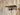 Steampunk industrial wall shelf with wood top and pipe fitting gauge on rustic wood panel wall