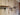 Industrial steampunk wall shelves with brass pipe fittings and vintage gauges on rustic wood paneling