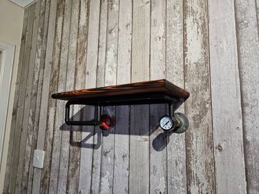 Industrial steampunk wall shelf with gauge and valve on rustic wooden panel wall