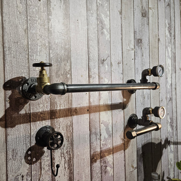 Industrial steampunk pipe towel rail and hooks with pressure gauges on rustic wood wall