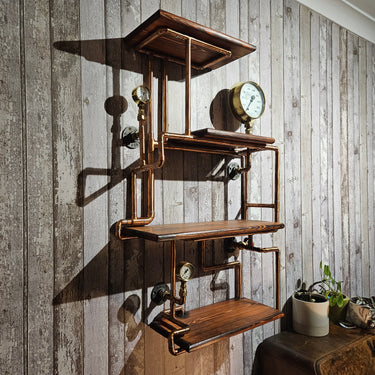 Steampunk industrial wall shelf with copper pipes, wood shelves, and vintage gauges