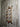 Wall-mounted steampunk industrial pipe shelf with red valve, rustic wood panel background
