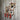 Industrial copper pipe coat rack with red hooks and pressure gauge on rustic wood wall