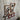 Industrial copper pipe coat rack with red hooks and gauge mounted on rustic wood wall
