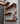 Industrial steampunk wall shelf with copper pipes, wood planks, and a pressure gauge.