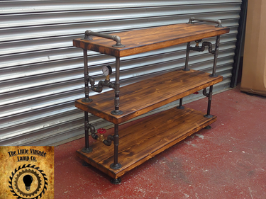 Handmade industrial shelving unit with wood shelves and metal pipe fittings, steampunk style