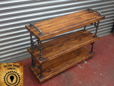 Industrial steampunk shelving unit with reclaimed wood and metal pipe frame, three tiers
