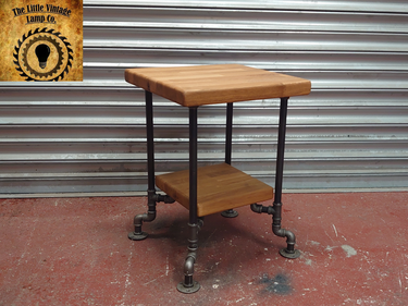Industrial side table with wooden shelves and black metal pipe legs, steampunk furniture style