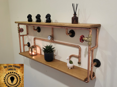 Handmade industrial pipe shelf with wooden planks, copper pipes, and steampunk decor.
