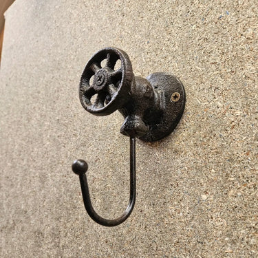 Industrial steampunk valve wall hook on textured background