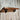 Industrial steampunk wall shelf with pipe brackets and rustic wood against distressed wall