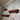 Set of three industrial pipe and wood wall shelves mounted on rustic wooden panel wall.