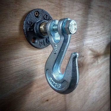 Industrial metal coat hook with steampunk design mounted on wooden wall