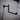 Industrial black iron pipe clothes hanger rail mounted on textured wall