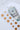 US twenty dollar bills in a white and gold polka dot envelope on a white surface