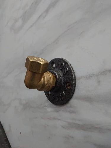 Retro industrial brass coat hook mounted on marble wall for rustic home decor