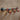 Industrial steampunk coat hooks made from metal pipes and red valve handles on wood wall