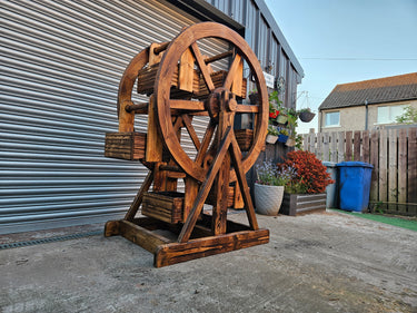 Handmade wooden Ferris wheel planter with rustic finish, outdoor industrial garden decor