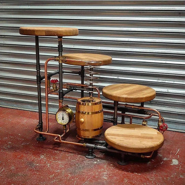 Rustic hardwood cake stand with steampunk industrial pipes, copper gauge, and barrel decor.