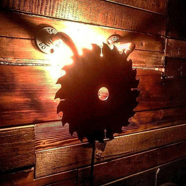 Rustic saw blade wall light with industrial pipe fittings on wooden wall
