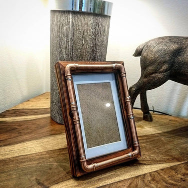 Steampunk copper pipe photo frame 6x4 on wooden table, industrial decor setting