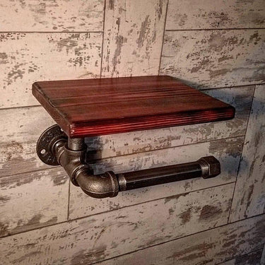 Steampunk toilet paper holder with steel pipe design and wooden shelf on rustic wall