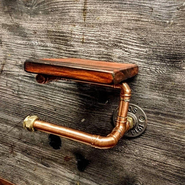 Steampunk copper pipe toilet paper holder with wood shelf on rustic wooden wall