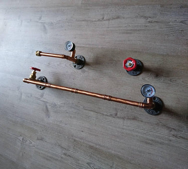 industrial steampunk pipe wall set with copper pipes, red valves, and pressure gauges on wooden background