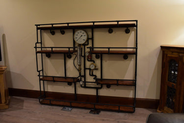 Steampunk industrial shelving unit with wood shelves and metal pipe frame featuring vintage gauges