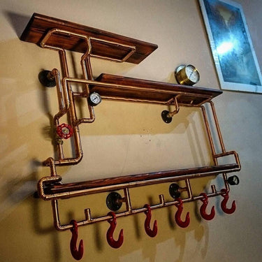 Steampunk industrial wall shelf with copper pipes, wood shelves, pressure gauge, and red hooks