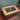 Steampunk coffee table with wooden frame, glass top, visible metal gears, and gauge