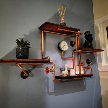 Industrial steampunk wall shelf with copper pipes, wood planks, pressure gauge, and decor
