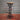 Industrial steampunk bar stool with metal pipe legs and wooden seat on a red floor