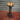 Industrial steampunk bar stool with wooden seat and metal pipe base, exposed fittings.