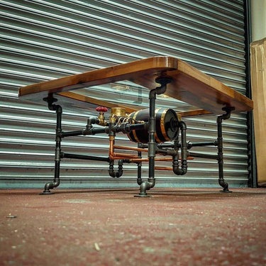 Steampunk coffee table with pipe legs, wooden top, and industrial metal fittings.
