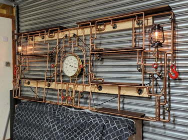 Industrial steampunk shelving unit with copper pipes, vintage gauge, lantern lights, and wood shelves.