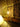 industrial pipe table lamp with exposed bulb on wooden shelf against stone wall