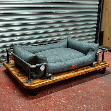 Steampunk dog bed with industrial pipes and wooden base, perfect for vintage decor