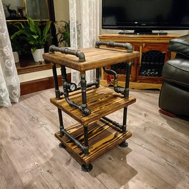 Steampunk side table with wooden shelves and industrial metal pipe frame in a living room setting