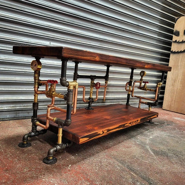 Steampunk coffee table with dark wood shelves and exposed metal pipes, industrial style decor