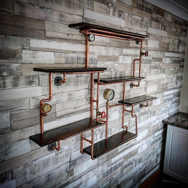 Steampunk wall shelving unit with copper pipes, wood shelves, and industrial gauges.