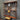 Steampunk shelving unit with copper pipes, wooden shelves, gauge, and industrial valves against metal wall
