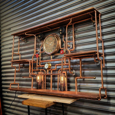 Handmade steampunk shelving unit with copper pipes, wooden shelves, gauges, and industrial lighting.