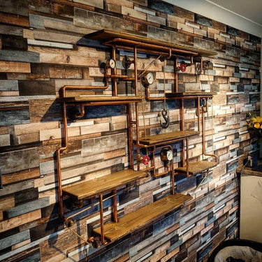 Steampunk industrial shelving unit with pipework, gauges, and wood shelves on rustic wall