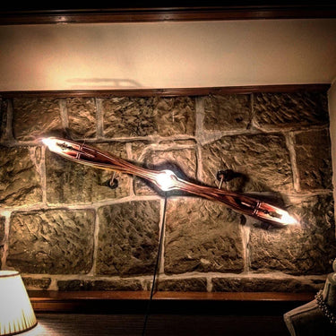 Steampunk propeller wall light fixture on rustic stone wall, industrial vintage decor
