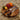 Round chunky walnut chopping board with knives, bell pepper, lemon, and lime on kitchen counter