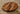 Thick round walnut chopping board with rich wood grain on a textured surface