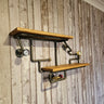 Industrial steampunk wall shelf with wood planks and metal pipe fittings on rustic panel wall