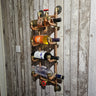 Handmade industrial pipe wine rack holding bottles on rustic wooden wall